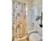 Bathroom with tub and shower featuring a colorful, decorative shower curtain and a small palm at 5137 Epping Ln, Zephyrhills, FL 33541