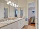 Bright bathroom featuring double sinks, white cabinetry and a view into the adjacent bedroom at 5137 Epping Ln, Zephyrhills, FL 33541