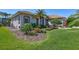 Charming home with beautiful landscaping, palm trees, and a well-maintained lawn at 5137 Epping Ln, Zephyrhills, FL 33541