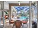 Relaxing screened lanai with dining set, offering views of the sparkling pool and outdoor lounging area at 5137 Epping Ln, Zephyrhills, FL 33541