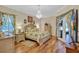 Spacious bedroom with hardwood floors, elegant chandelier, and a beautiful decorative bed at 5137 Epping Ln, Zephyrhills, FL 33541