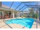 Relaxing screened-in pool area with brick pavers, covered seating, and lush landscaping at 5137 Epping Ln, Zephyrhills, FL 33541