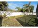 Spacious backyard with a manicured lawn, white fence, and lush greenery, perfect for outdoor activities at 527 Manns Harbor Dr, Apollo Beach, FL 33572