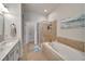Bathroom featuring a glass-enclosed shower, soaking tub, and modern fixtures at 527 Manns Harbor Dr, Apollo Beach, FL 33572