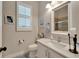 Well-lit bathroom featuring a modern vanity, a framed mirror, and a shuttered window at 527 Manns Harbor Dr, Apollo Beach, FL 33572