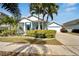Attractive single-Gathering home with a blue exterior, palm trees, and lush landscaping, exuding charm at 527 Manns Harbor Dr, Apollo Beach, FL 33572