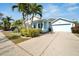 Inviting blue home with palm trees and a driveway leading to a garage, showcasing curb appeal at 527 Manns Harbor Dr, Apollo Beach, FL 33572