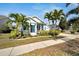 Charming blue single-Gathering home with a manicured lawn, lush landscaping, and a welcoming front porch at 527 Manns Harbor Dr, Apollo Beach, FL 33572