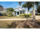 Charming blue single-story home featuring a welcoming front porch and lush tropical landscaping at 527 Manns Harbor Dr, Apollo Beach, FL 33572
