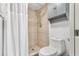 Tiled shower with neutral tones features a shower head and tiled flooring, with a toilet and cabinet nearby at 6265 Sun Blvd # 1201, St Petersburg, FL 33715