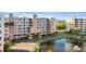 Exterior of a condominium complex with lush landscaping, pond with fountain, and ample parking at 6495 Shoreline Dr # 8106, St Petersburg, FL 33708