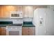 Bright kitchen with white appliances, wood cabinets and dark countertops at 6495 Shoreline Dr # 8106, St Petersburg, FL 33708