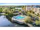 Aerial view of the community pool and spa overlooking the lake with ample seating and lush landscaping at 6495 Shoreline Dr # 8106, St Petersburg, FL 33708