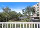 Balcony view of a serene lake, lush greenery, and a glimpse of the condo's covered parking at 6495 Shoreline Dr # 8106, St Petersburg, FL 33708