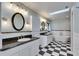 Bright bathroom boasts dual vanities, soaking tub, black and white checkered floor, and a skylight at 6603 Seabird Way, Apollo Beach, FL 33572