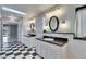 Sunlit bathroom featuring dual vanities with granite countertops and checkered tile flooring at 6603 Seabird Way, Apollo Beach, FL 33572