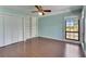Bedroom with wood flooring, a window, a large closet with white doors, and a large built-in bookcase at 6603 Seabird Way, Apollo Beach, FL 33572
