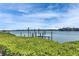 Scenic view of a private dock on the water, surrounded by lush greenery and a blue sky at 6603 Seabird Way, Apollo Beach, FL 33572