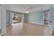 Open living space with hardwood floors, white curtains, ceiling fan and a view of the screened-in patio at 6603 Seabird Way, Apollo Beach, FL 33572