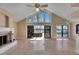 Open living room with a fireplace, high windows, and sliding glass doors to outdoor hot tub at 6603 Seabird Way, Apollo Beach, FL 33572