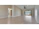 Spacious living room with light wood floors, ceiling fan, and sliding glass doors to a patio and water view at 6603 Seabird Way, Apollo Beach, FL 33572