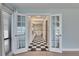 Ensuite bathroom featuring black and white checkered floors, skylights, and a garden bathtub at 6603 Seabird Way, Apollo Beach, FL 33572