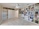 Home office featuring wall-to-wall built-in shelving, storage cabinets and tile flooring at 6603 Seabird Way, Apollo Beach, FL 33572
