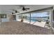 Spacious covered patio featuring a brick floor, ceiling fans, access to the pool, and a view of the waterfront at 6603 Seabird Way, Apollo Beach, FL 33572