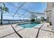 Enclosed pool area with a brick patio and a view of the canal in the distance at 6603 Seabird Way, Apollo Beach, FL 33572