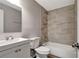 Well-lit bathroom featuring a stylish vanity, toilet, and tiled shower-over-tub at 7101 Kingston Dr, Tampa, FL 33619