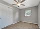 Cozy bedroom features neutral walls, ceiling fan, carpet, and window for natural light at 7101 Kingston Dr, Tampa, FL 33619