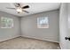 Bedroom featuring carpeting, two windows, a ceiling fan, and gray walls at 7101 Kingston Dr, Tampa, FL 33619