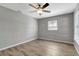 A well lit bedroom with wood-look flooring, modern fan and gray walls at 7101 Kingston Dr, Tampa, FL 33619