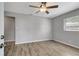 Bright bedroom with wood-look flooring, neutral gray walls, and a ceiling fan at 7101 Kingston Dr, Tampa, FL 33619