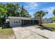 View of a well-maintained home with driveway, lawn and palm tree at 7101 Kingston Dr, Tampa, FL 33619
