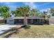 Neat one-story house featuring a well-kept lawn, palm tree, and a screened porch at 7101 Kingston Dr, Tampa, FL 33619