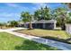 Quaint single-Gathering home with a lush green lawn and sidewalk leading to the front porch at 7101 Kingston Dr, Tampa, FL 33619