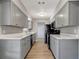 Charming galley kitchen featuring gray cabinets, sleek appliances, and light countertops at 7101 Kingston Dr, Tampa, FL 33619