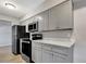 Modern kitchen with gray cabinets, stainless appliances, and light countertops at 7101 Kingston Dr, Tampa, FL 33619