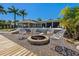 Inviting backyard featuring a fire pit, modern patio furniture, and lush tropical landscaping at 714 Bayshore Dr, Tarpon Springs, FL 34689