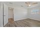 Bedroom features wood floors, a ceiling fan, and ample natural light coming in from the window and open door at 714 Bayshore Dr, Tarpon Springs, FL 34689
