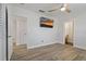 Bright bedroom with wood-look tile, ceiling fan, and wall-mounted TV for relaxing evenings at 714 Bayshore Dr, Tarpon Springs, FL 34689