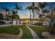 Charming single-story home with a well-manicured lawn and beautiful landscaping, including mature palm trees at 714 Bayshore Dr, Tarpon Springs, FL 34689