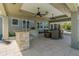 Spacious covered outdoor patio featuring a stone-clad bar area and a dining set for entertaining guests at 714 Bayshore Dr, Tarpon Springs, FL 34689