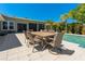 Outdoor dining area adjacent to the pool with a large patio table and chairs at 714 Bayshore Dr, Tarpon Springs, FL 34689