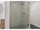 Close-up of a glass shower with gray and white marbled tile and contrasting mosaic floor tile at 714 Bayshore Dr, Tarpon Springs, FL 34689