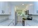 Well-lit kitchen featuring granite countertops, stainless appliances, and white cabinets at 804 Shore W Dr, Oldsmar, FL 34677