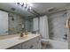 Well-lit bathroom with a shower-tub combination, vanity, and floral wallpaper at 895 S Gulfview Blvd # 309, Clearwater Beach, FL 33767