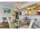 Dining room with glass table, chandelier, and view to the kitchen at 895 S Gulfview Blvd # 309, Clearwater Beach, FL 33767