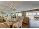 Bright dining area with a glass table, upholstered chairs, and mirrored wall with water view at 895 S Gulfview Blvd # 309, Clearwater Beach, FL 33767